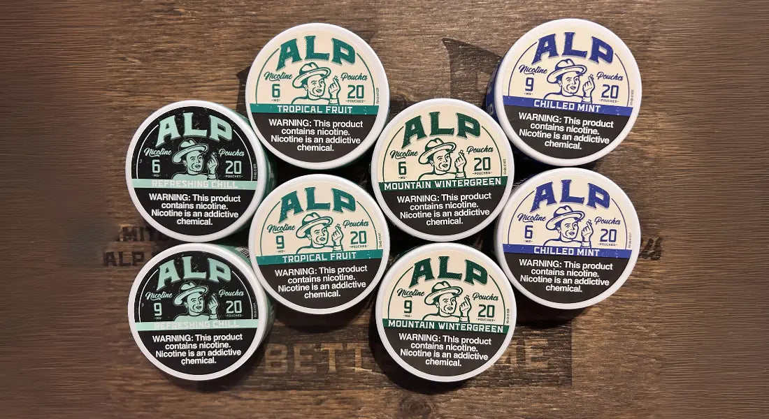 High-strength nicotine pouch containers in various flavors and strengths displayed on a wooden surface.