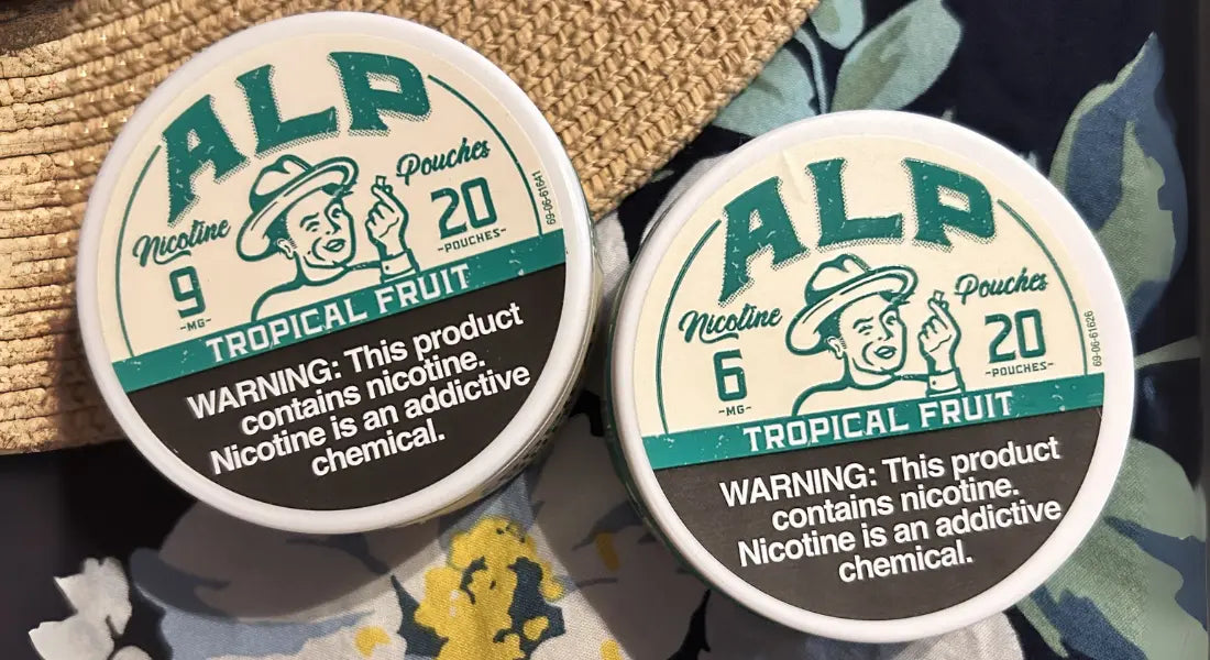 Flavored nicotine pouches from ALP in Tropical Fruit are displayed in 6mg and 9mg strengths, featuring bold packaging and a warning label