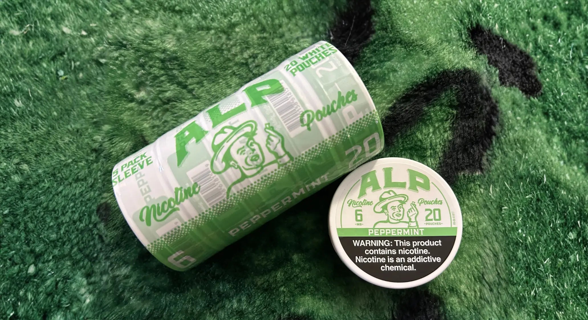 ALP Peppermint refreshing oral nicotine 5-pack sleeve and single tin displayed side by side on a green turf surface.